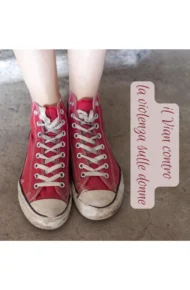 Un paio di scarpe da ginnastica rosse, indossate da una giovane ragazza, di cui vediamo solo i piedi, con la scritta 